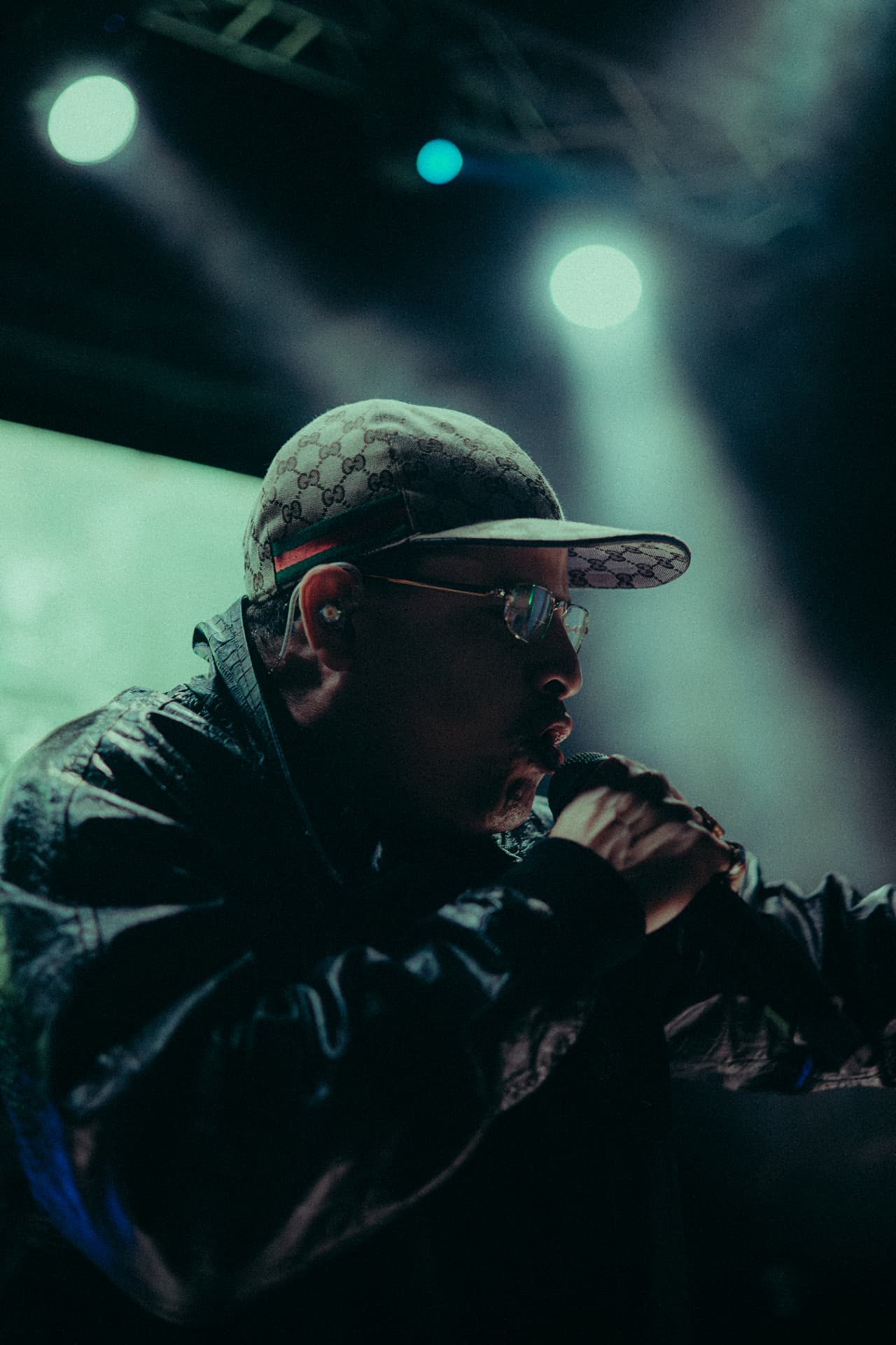 Artista en escenario con luces verdes y humo
